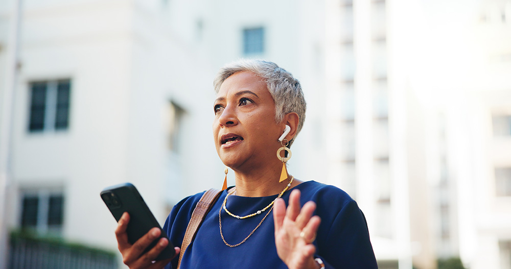 Woman with vocal hoarseness speaks into a cell phone.